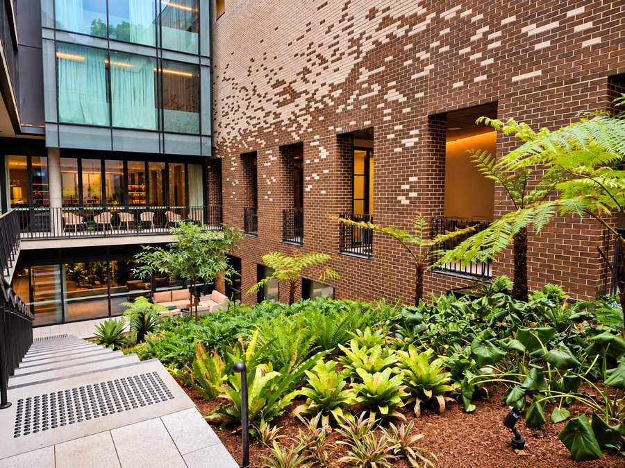 25hours Hotel The Olympia, courtyard garden against the patterned brick wall