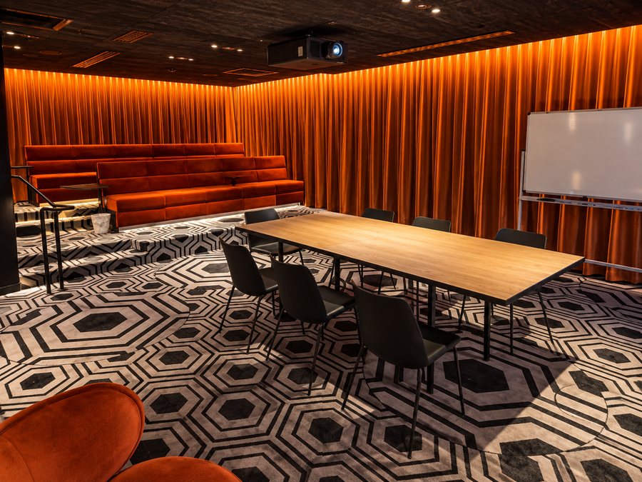 25hours Hotel The Olympia, meeting room with tiered velvet seating and a boardroom table
