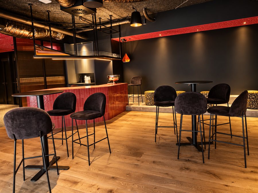 25hours Hotel The Olympia, event space bar with a red tiled counter and high tables