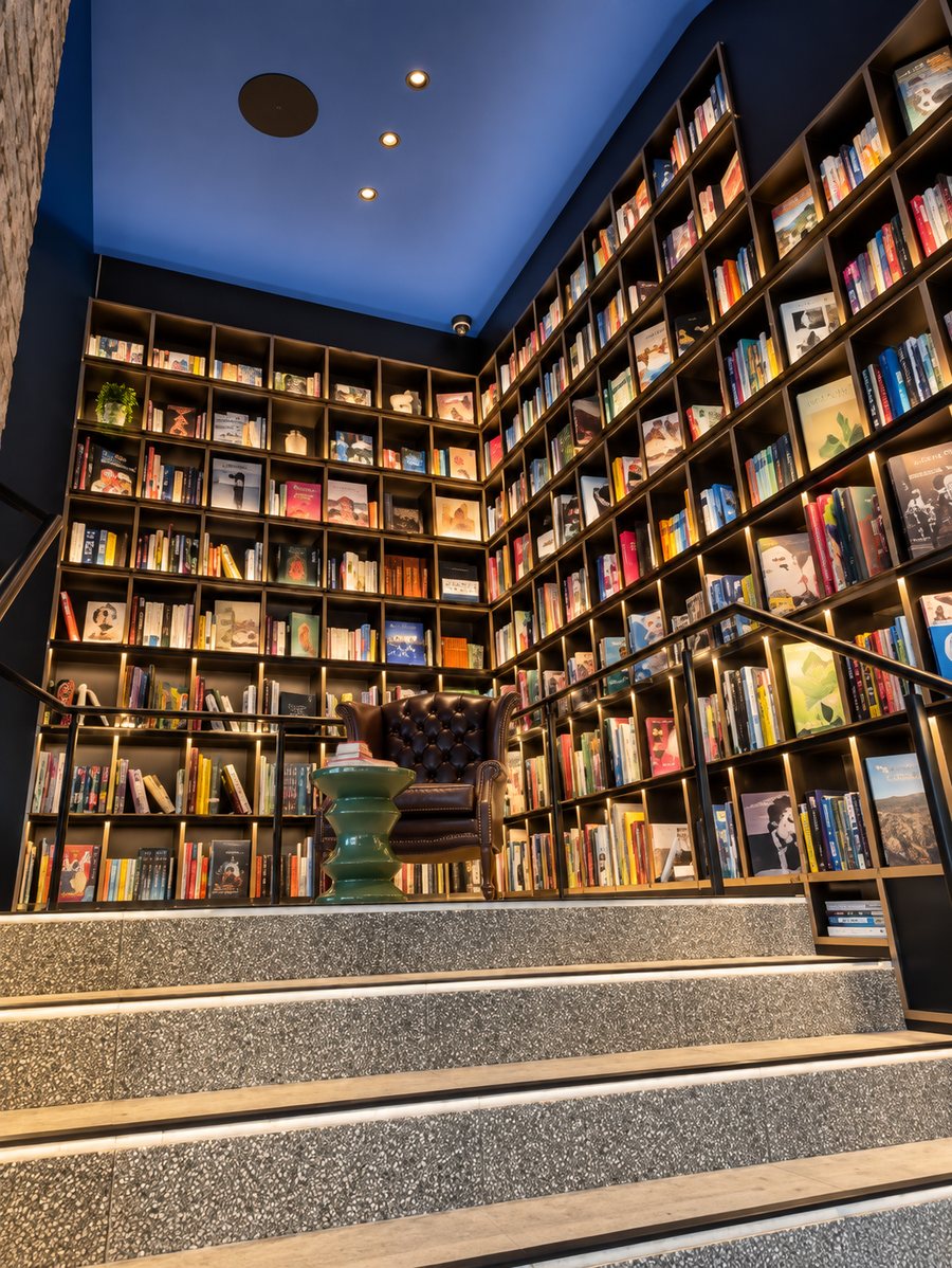 25hours Hotel The Olympia, book lined stair landing with a reading chair