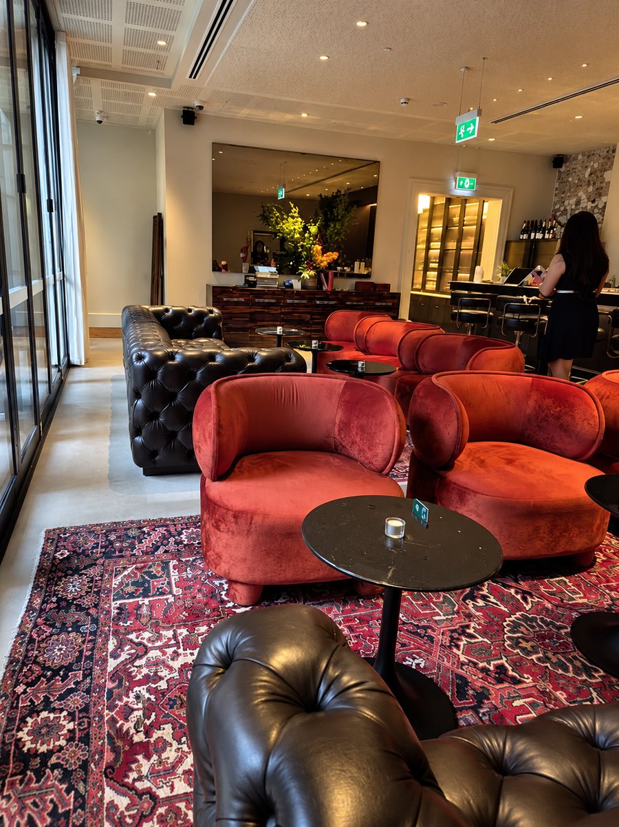 25hours Hotel The Olympia, lounge with velvet armchairs and leather sofas