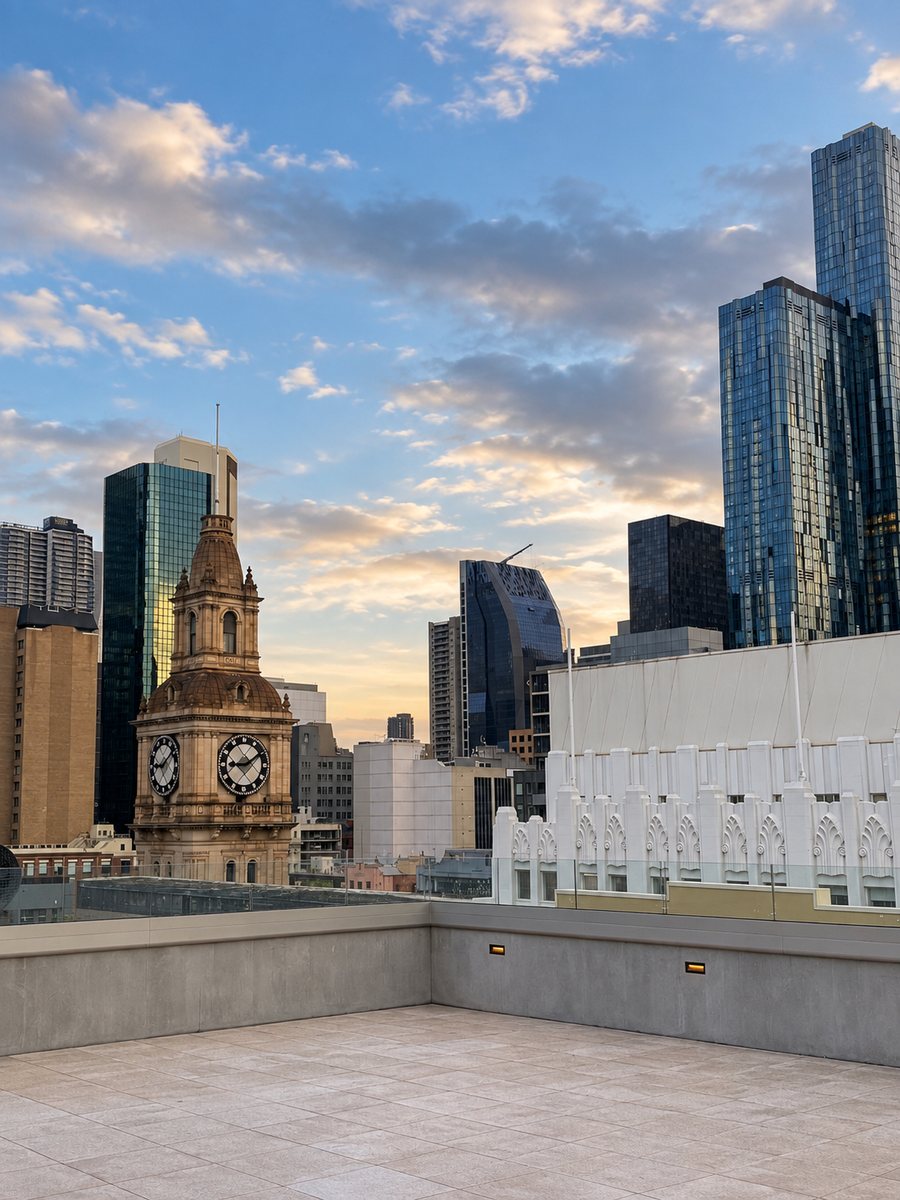 Holiday Inn Melbourne Bourke Street Mall, open paved rooftop terrace looking to the GPO clock tower and the city skyline at dusk