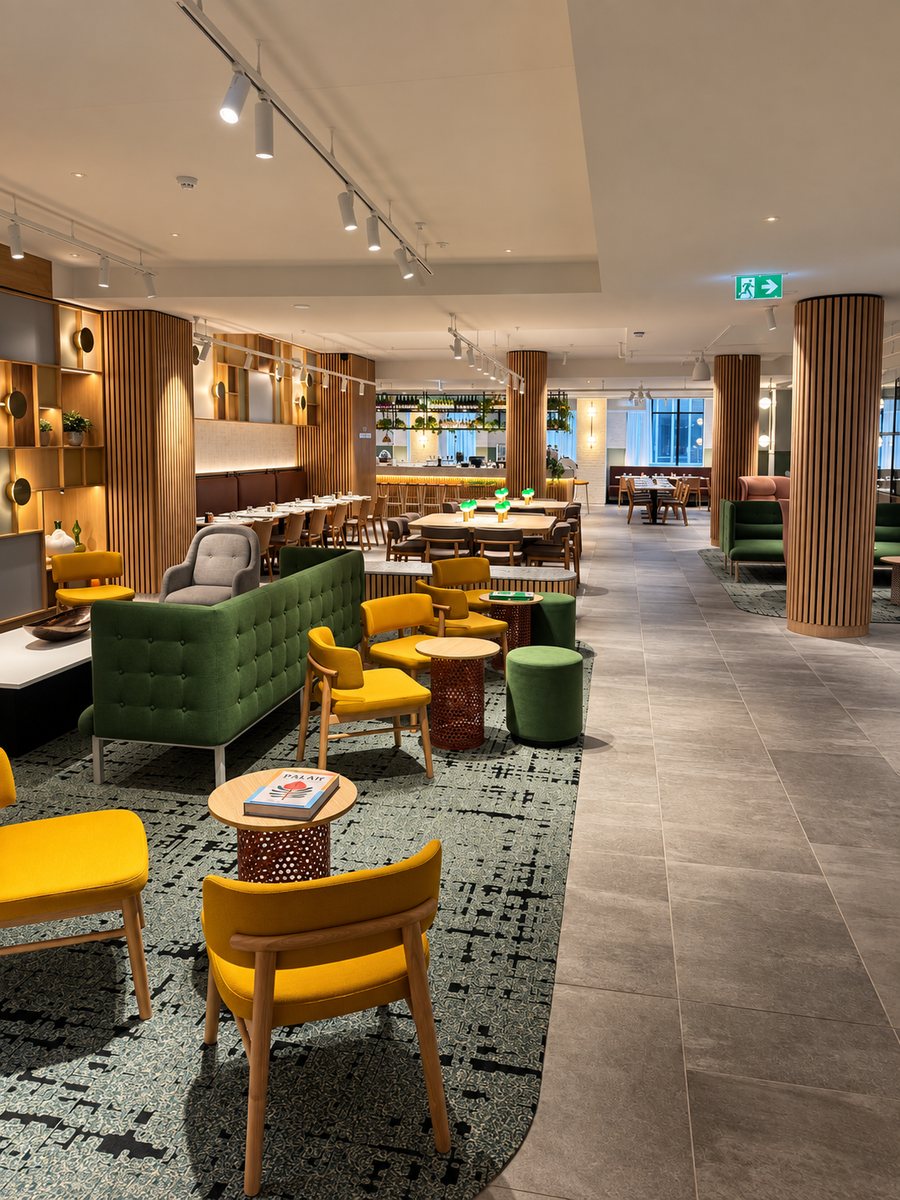 Holiday Inn Melbourne Bourke Street Mall, open lobby with mustard armchairs, a green buttoned sofa and slatted timber columns