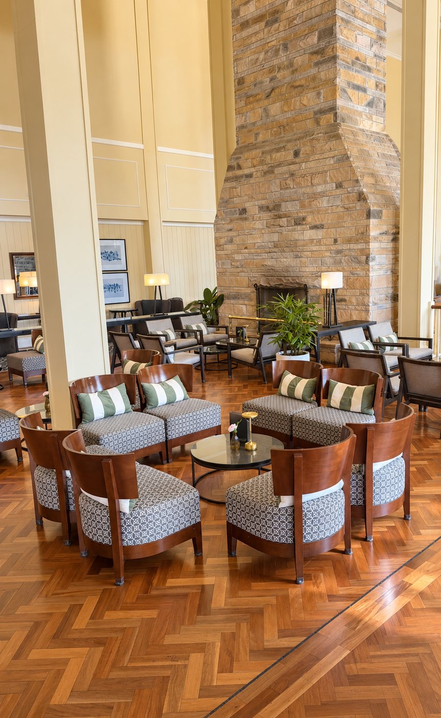 InterContinental Sanctuary Cove Resort, lobby lounge with timber armchairs on a herringbone floor below a sandstone fireplace