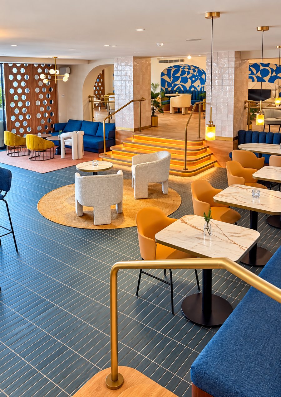 Kimpton Los Monteros Marbella, lounge with blue banquettes, marble topped tables and lit timber steps to a second level