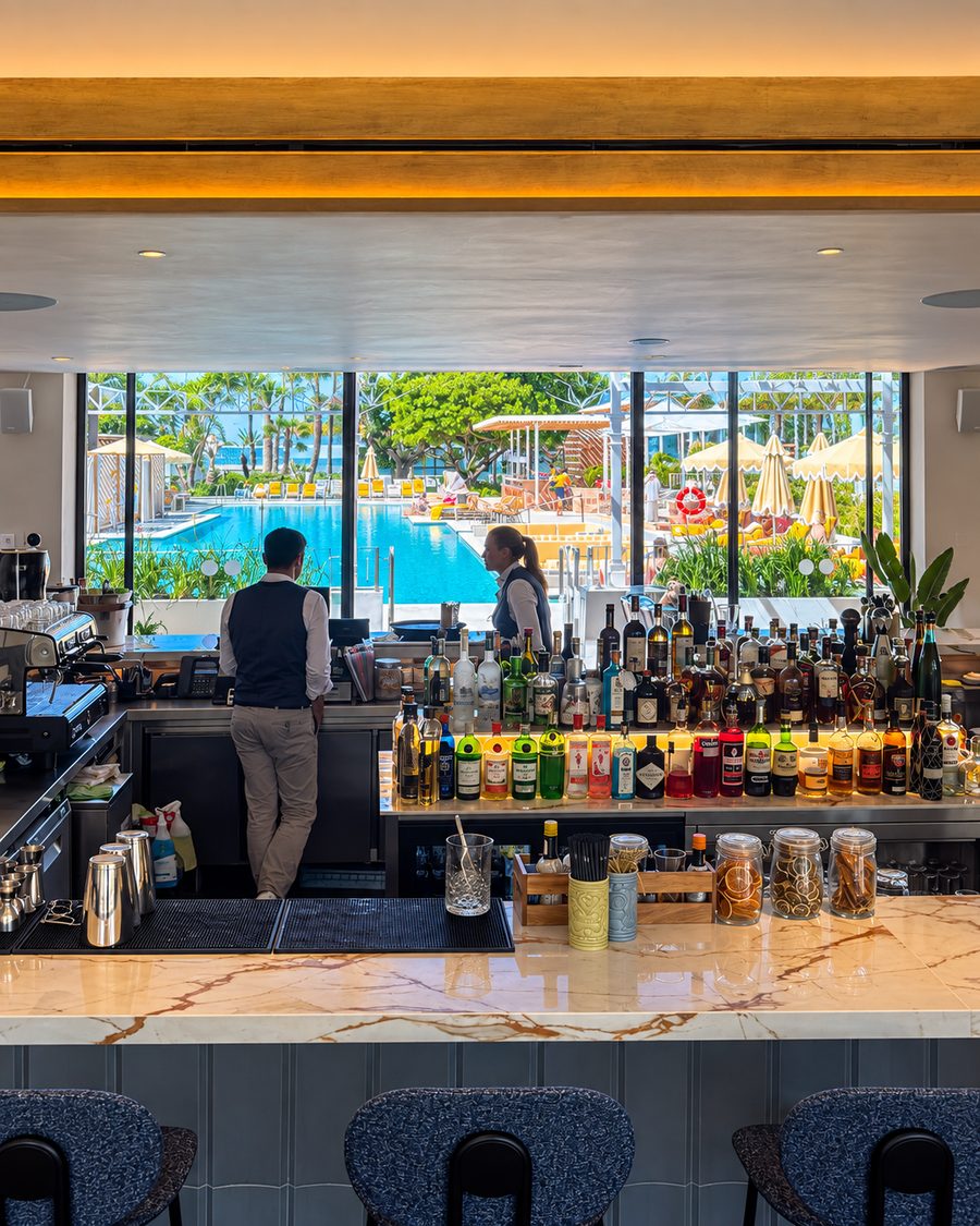 Kimpton Los Monteros Marbella, bar with backlit bottle shelving and a window onto the pool
