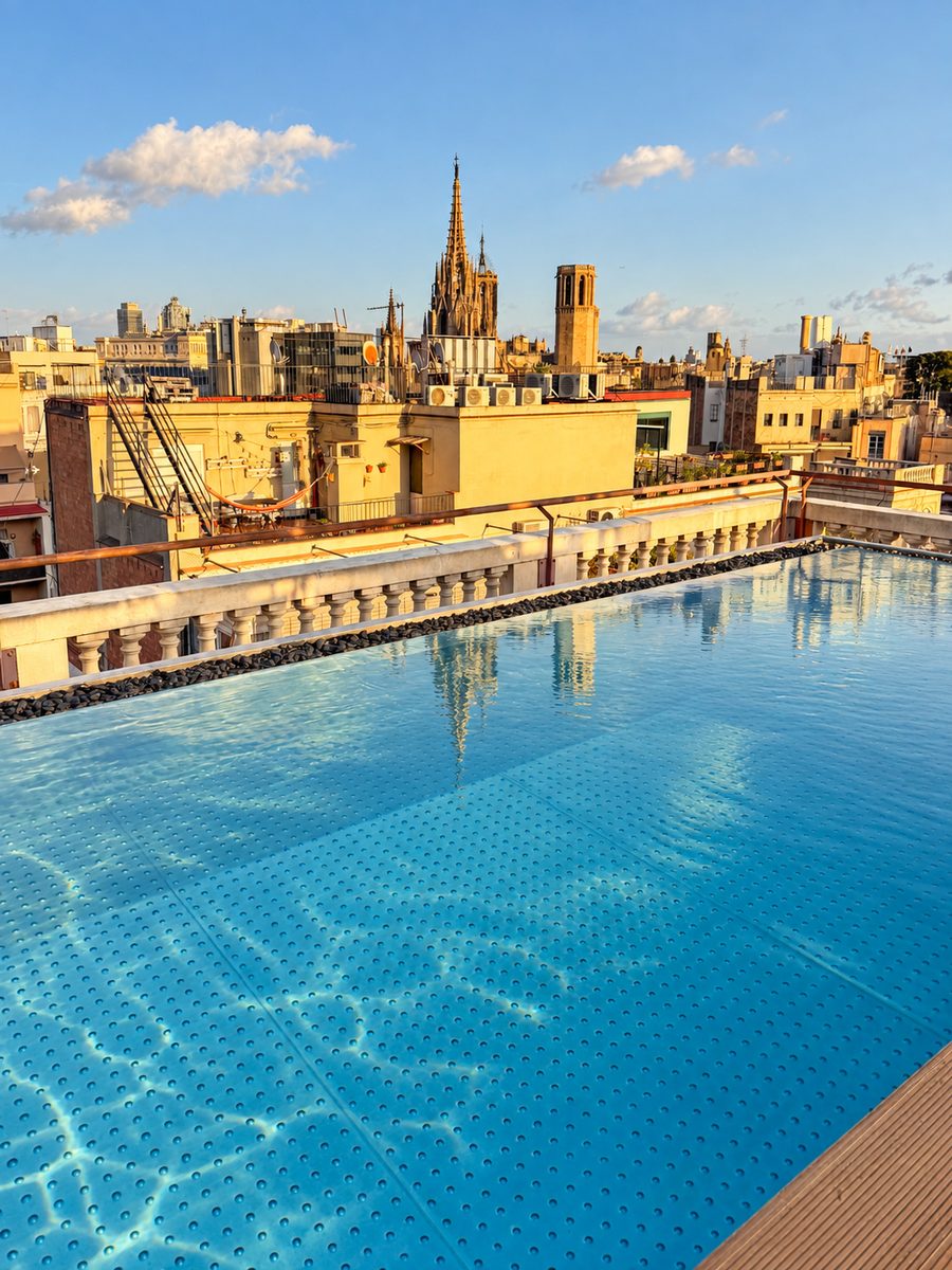 Kimpton Vividora Barcelona, rooftop pool with the cathedral spire and Gothic Quarter rooftops behind