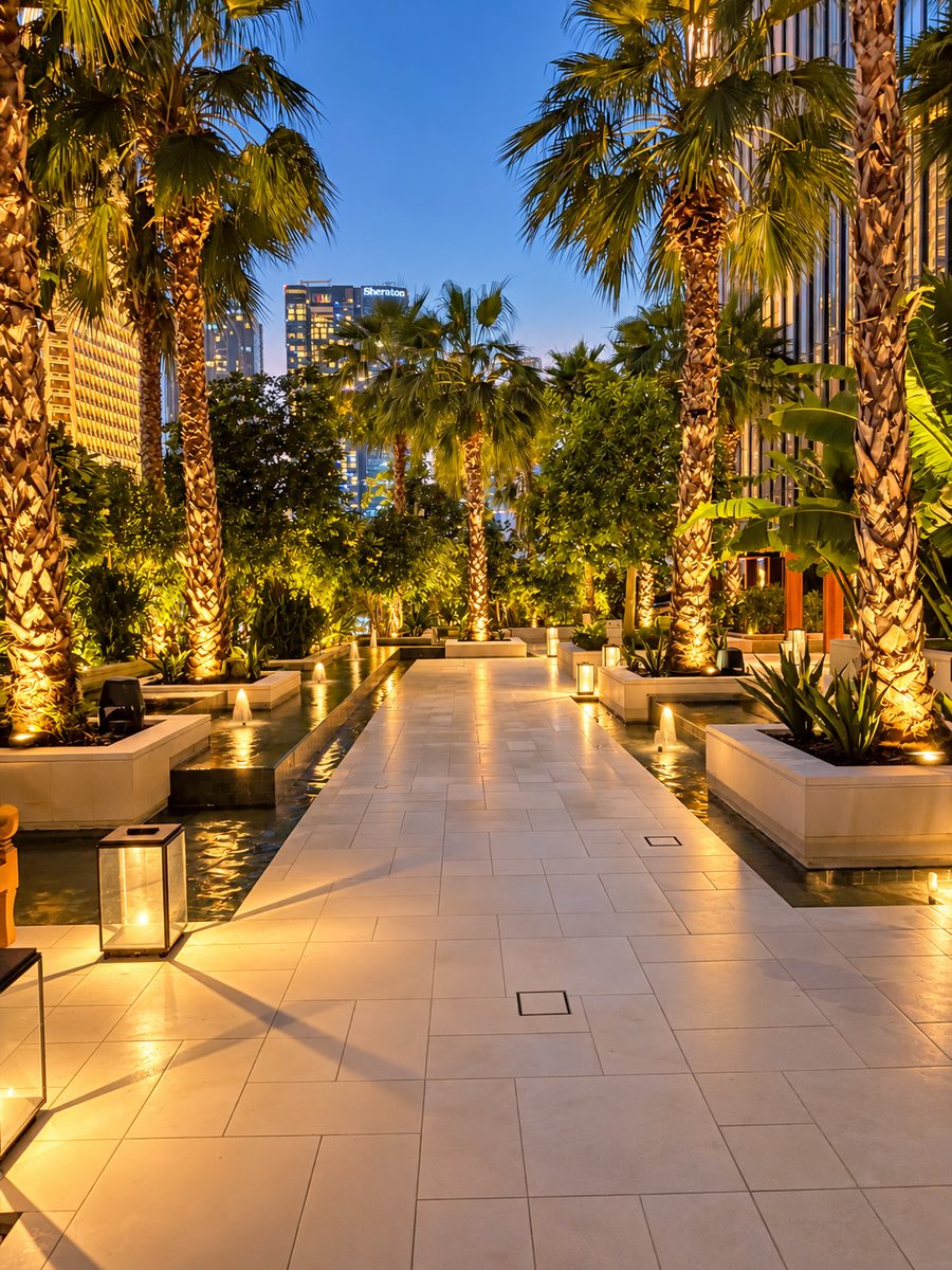 One&Only One Za’abeel, garden walkway lined with lit palms, lanterns and water channels at night