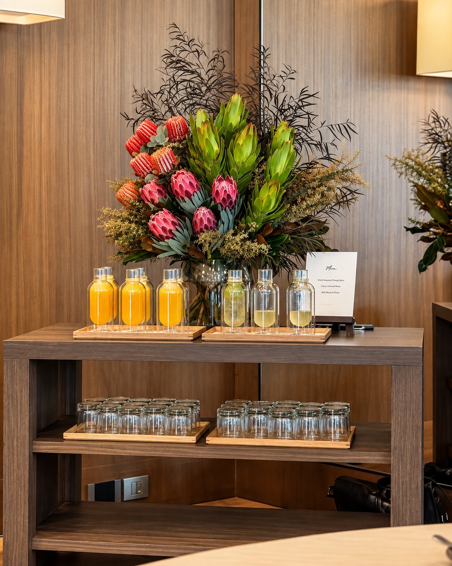 Park Hyatt Sydney, refreshment station of juices and infused water under a native flower arrangement against timber panelling